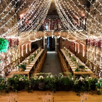 Wooden Trestle Tables Set-Up for Dinner in the Main Vault of The Caves, Edinburgh, with Additional Fairy Lights.