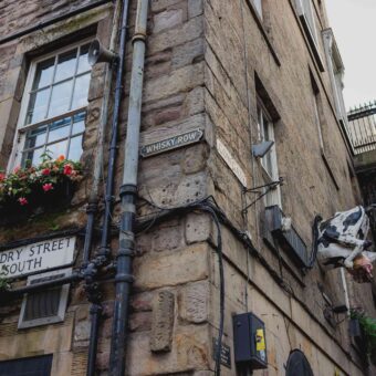 The Corner of Niddry Street South, with The Rowantree's Famous Cow and Whisky Row Sign.